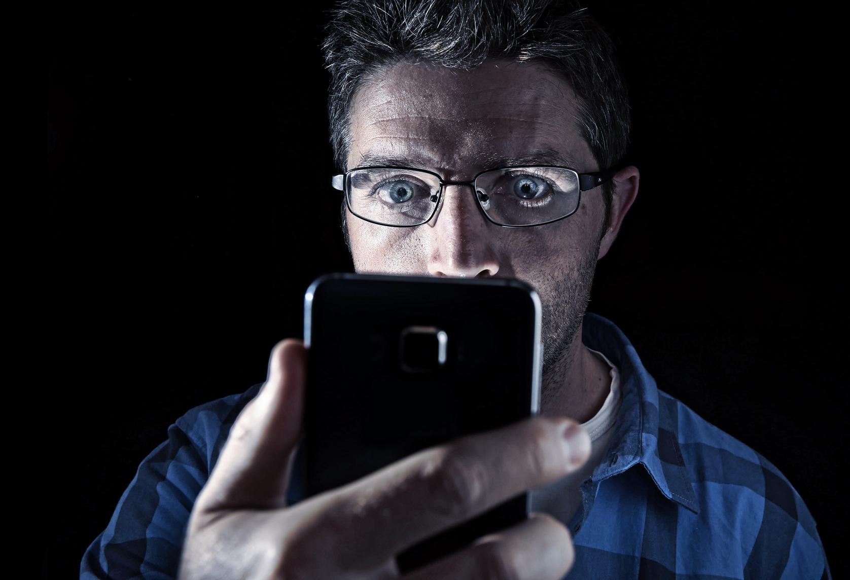 Man with a smartphone with a black background