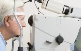 Older man looking into an optometric machine