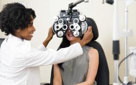 Optometrist giving a young woman an eye exam