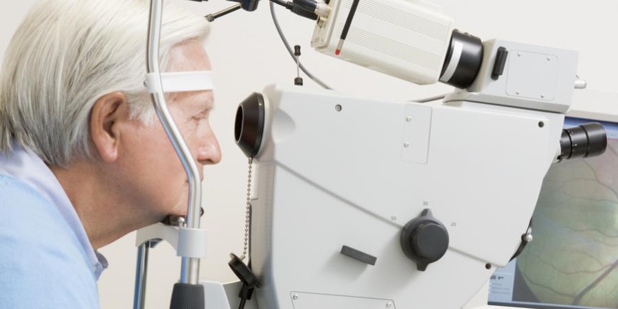 Older man looking into an optometric machine